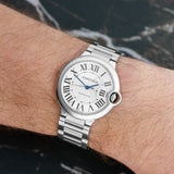 Front view of a Cartier Ballon Bleu W6920046 watch featuring a polished stainless steel case, 36mm size, and a classic round dial with Roman numerals and a blue cabochon crown.