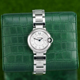 Front view of a Cartier Ballon Bleu WE902073 watch featuring a stainless steel case and a 28mm size, showcasing its elegant design and distinctive blue cabochon crown.