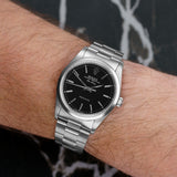 Front view of a Rolex Air King 14000 featuring a stainless steel case and a 34mm diameter. The watch has a classic black dial with white hour markers and hands, accented by the iconic Rolex crown logo at 12 o'clock.
