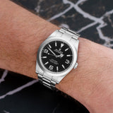 Front view of a Rolex Explorer 214270 featuring a stainless steel case and a 39mm size, showcasing a black dial with white hour markers and luminescent hands.