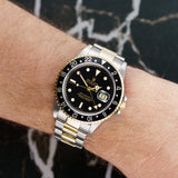 Front view of a Rolex GMT Master II 16713 featuring a stainless steel and yellow gold case, 40mm size, with a black bezel and multi-colored dial.
