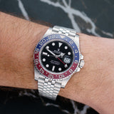 Front view of a Rolex GMT Master II 126710BLRO, featuring a 40mm stainless steel case, black and blue ceramic bezel, and a black dial with luminous hour markers and hands.